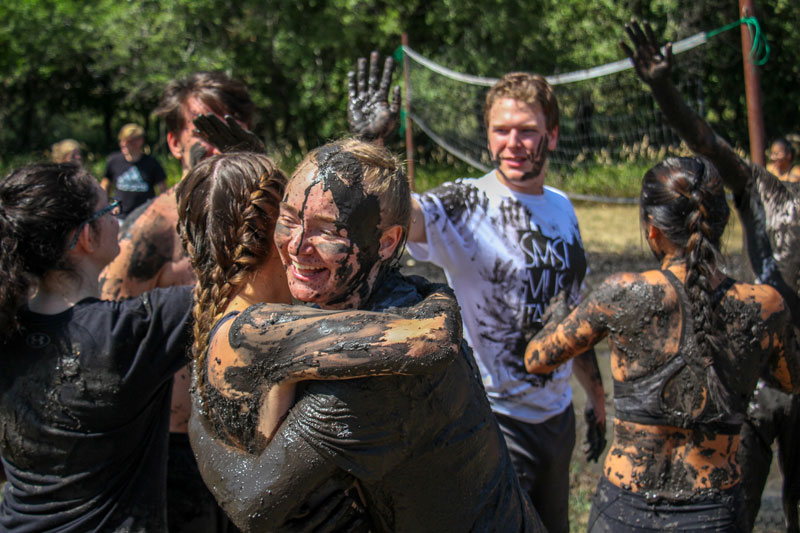 Students playing mud volleyball