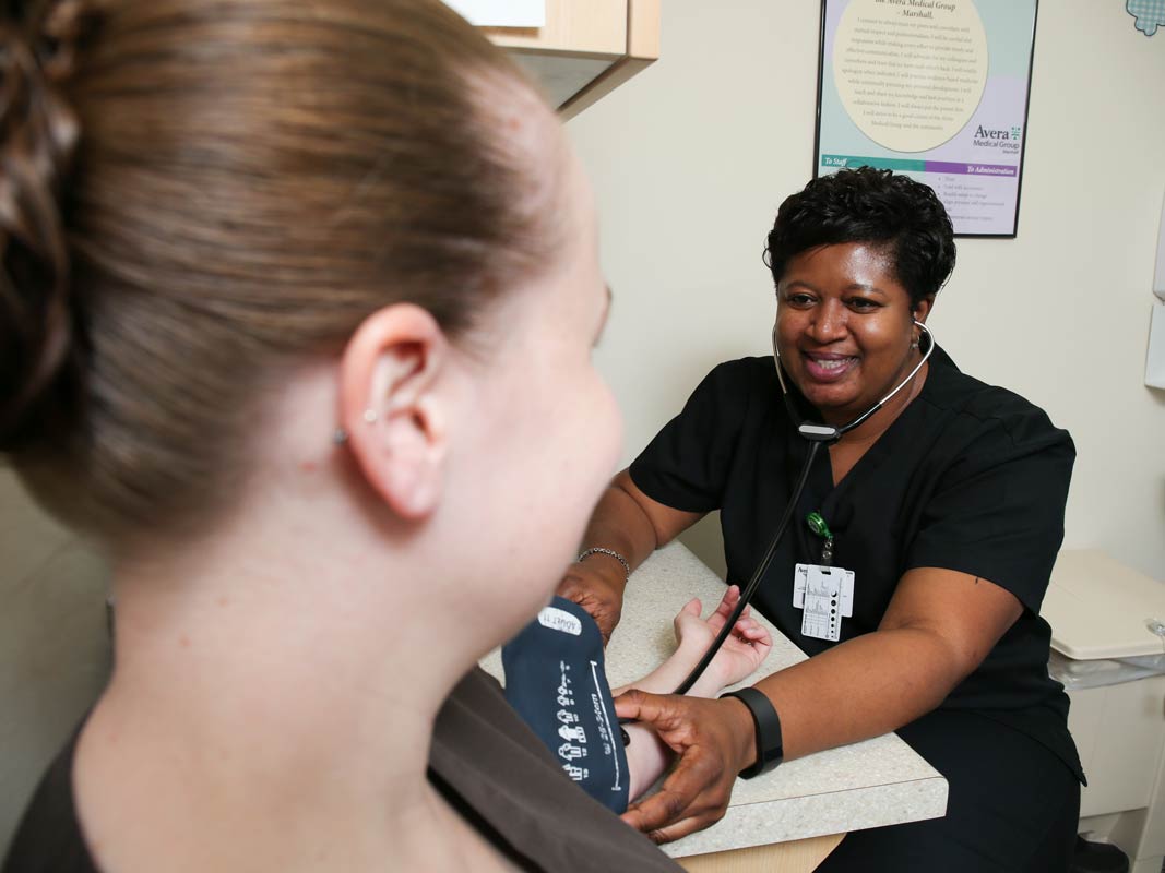 nurse taking blood pressure of patient