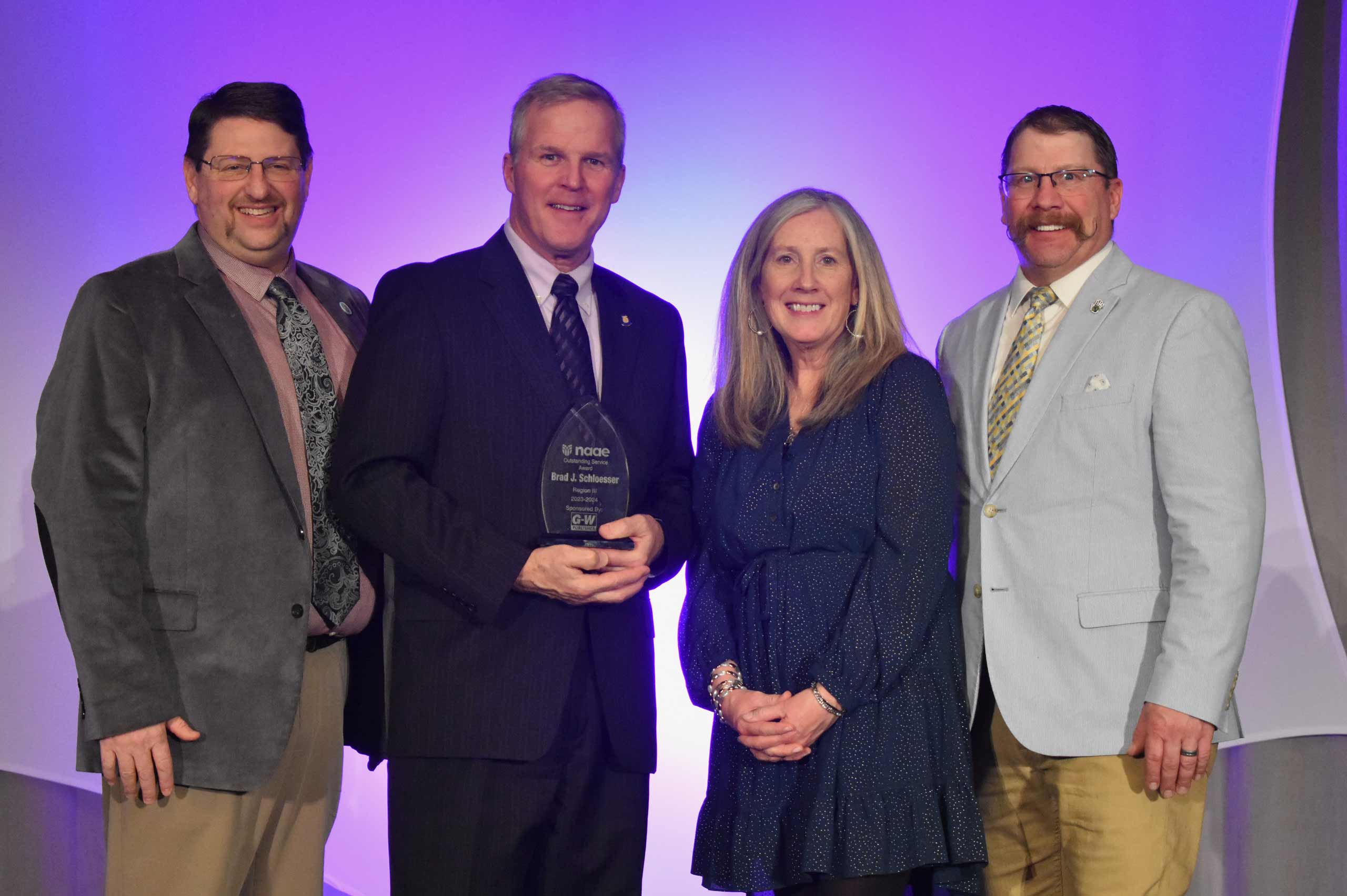 Photo (l-r): Paul Aarvold, NAAE, Region III Vice President; Brad Schloesser; Maureen Brennan, Goodheart-Willcox Publisher; Eric Tilleman, NAAE, 2023-2024 President